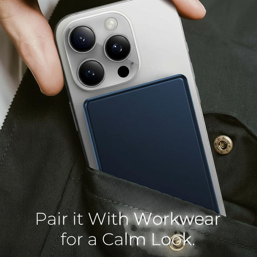 Blessing's navy blue magnetic wireless charging power bank attached to a silver smartphone, tucked into a dark green jacket pocket.
