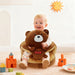 Blessing Sells brown plush toddler seat shaped like a teddy bear, with a happy baby sitting in it.