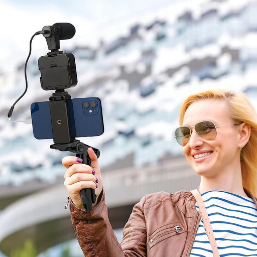 Blessing Sells smartphone vlogging kit with microphone and LED light attached to a blue iPhone on a tripod grip.