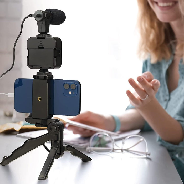 Blessing Sells smartphone vlogging kit with microphone, LED light, and tripod. A woman is blurred in the background.